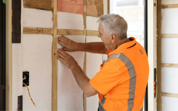 Man installing insulation into a wall