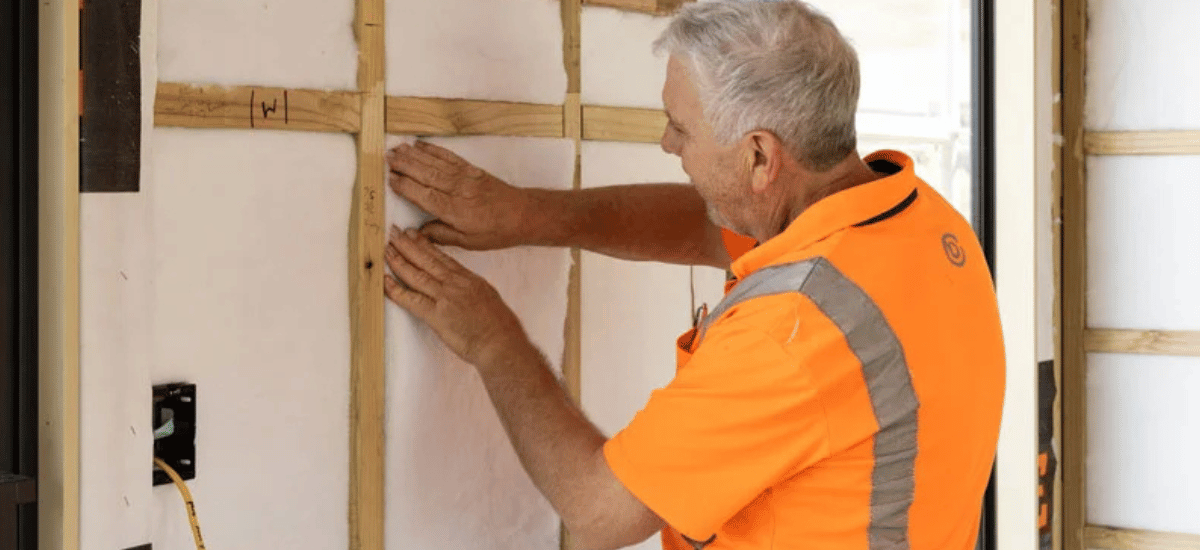 Man installing insulation into a wall